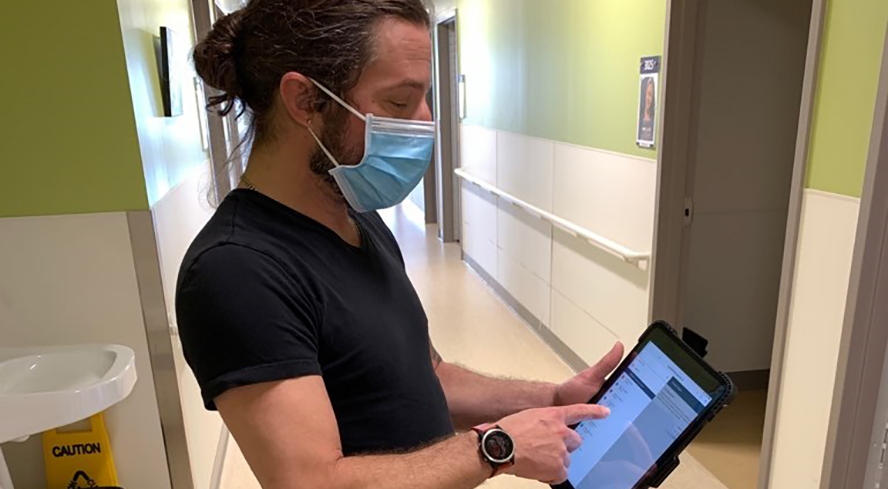 Attendant in a residential unit working with a digital tablet.